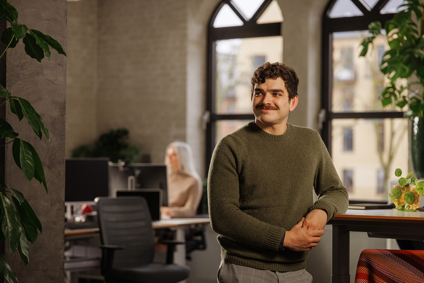Man standing at desk looking away from the camera