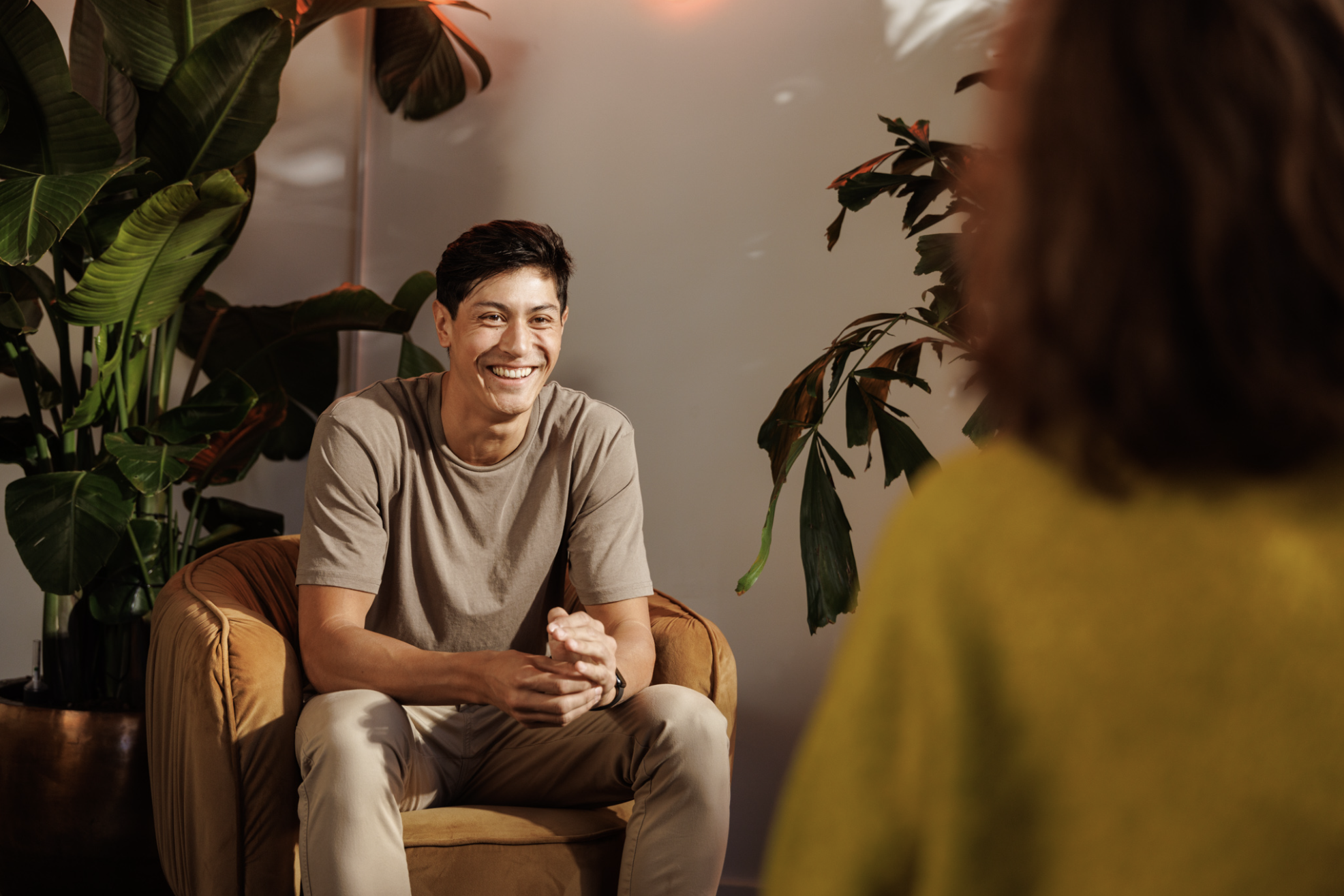 Man sitting on a sofa having a conversation with the person in front of him